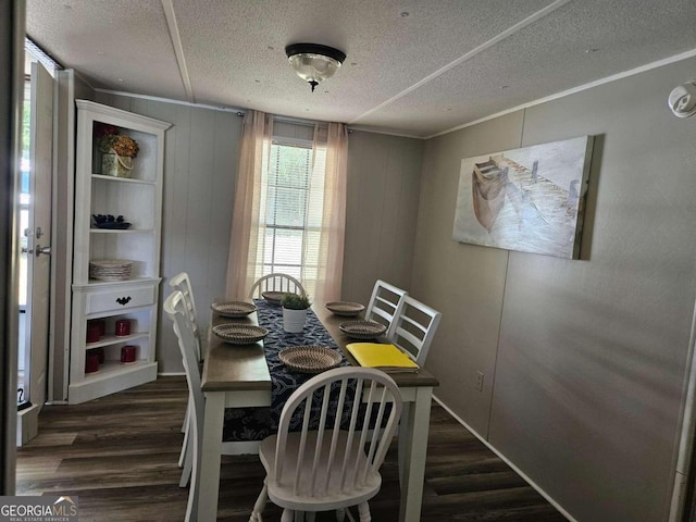 dining area with a textured ceiling, dark wood-type flooring, and crown molding