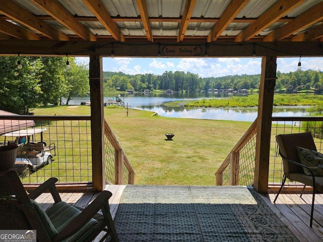 wooden deck with a yard and a water view