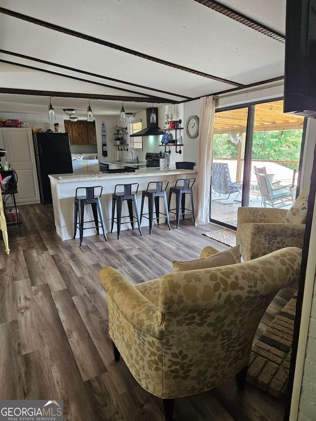 living room featuring hardwood / wood-style flooring, a textured ceiling, and vaulted ceiling