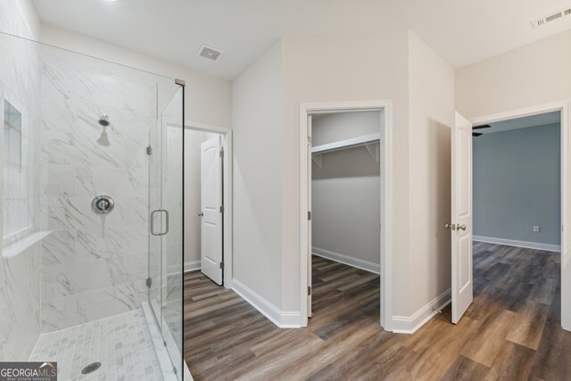 bathroom featuring hardwood / wood-style flooring and a shower with shower door