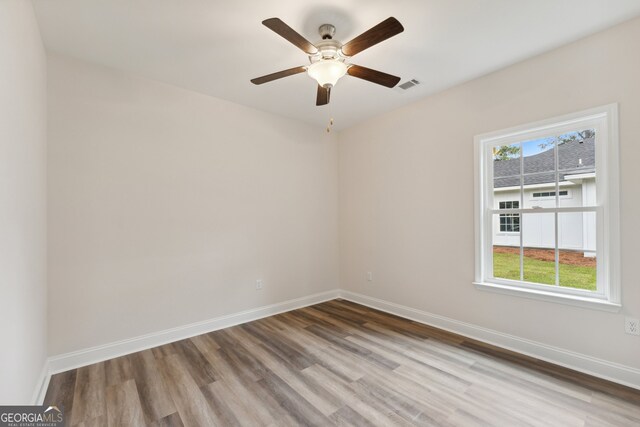 spare room featuring wood-type flooring and ceiling fan