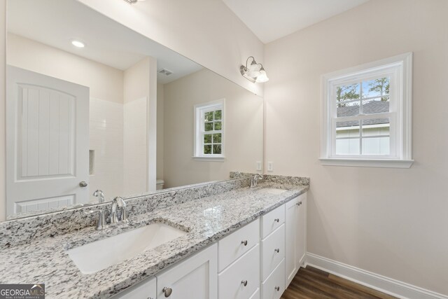 bathroom with vanity, toilet, a wealth of natural light, and hardwood / wood-style flooring