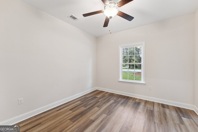 empty room featuring ceiling fan and dark hardwood / wood-style flooring