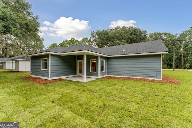 back of property with a lawn and a patio area