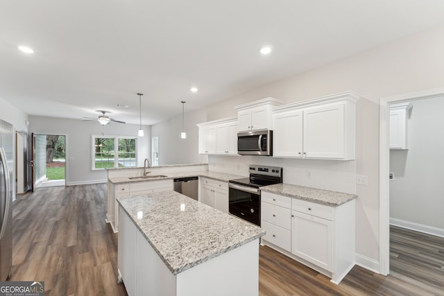 kitchen featuring white cabinets, stainless steel appliances, sink, kitchen peninsula, and ceiling fan