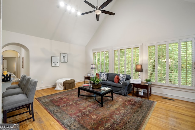 living room with wood-type flooring, ceiling fan, high vaulted ceiling, and a wealth of natural light