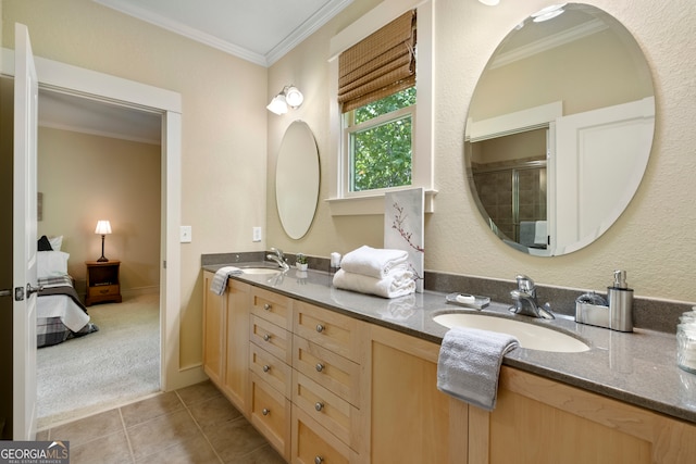 bathroom featuring vanity, a shower with shower door, crown molding, and tile patterned floors