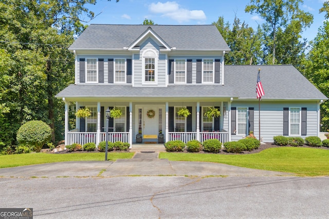 colonial-style house with a porch and a front lawn