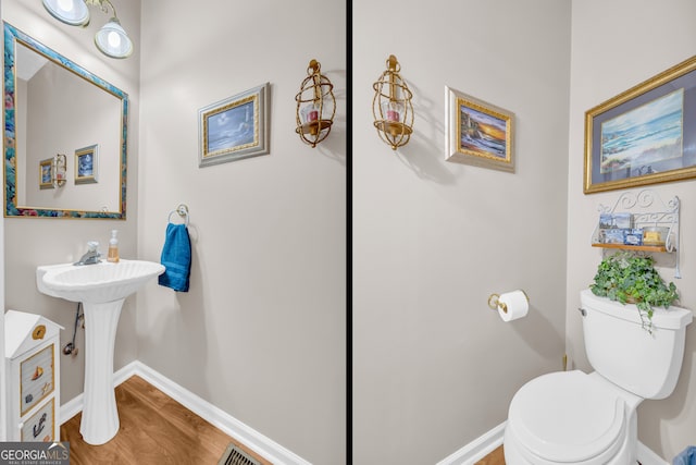 bathroom with toilet and hardwood / wood-style floors