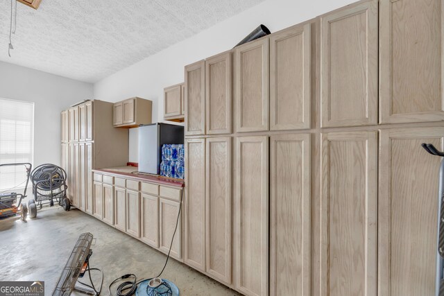 kitchen featuring light brown cabinets and a textured ceiling