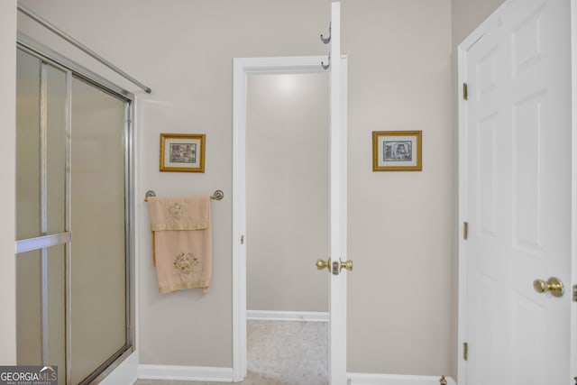 bathroom featuring a shower with door