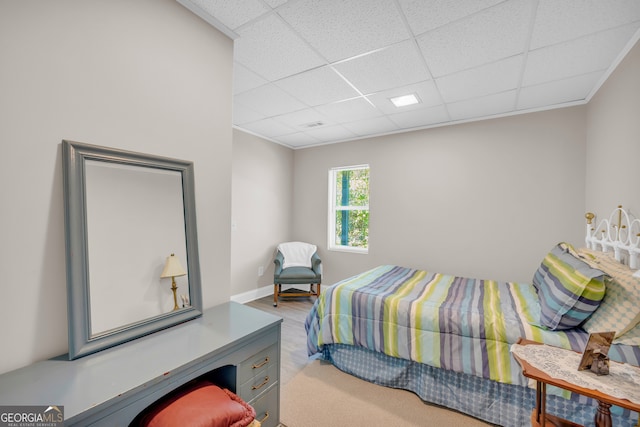 bedroom featuring light wood-type flooring and a paneled ceiling