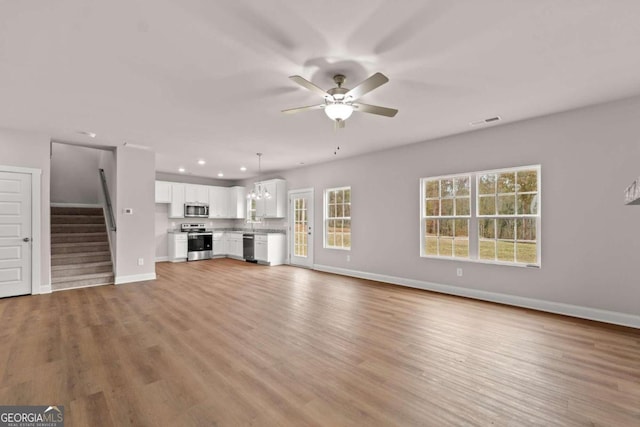 32 Joseph Ln, Hartwell, GA 30643 - unfurnished living room featuring a ceiling fan, stairs, recessed lighting, and light wood-type flooring