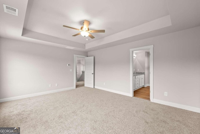32 Joseph Ln, Hartwell, GA 30643 - unfurnished bedroom featuring a raised ceiling, carpet floors, ensuite bath, and a ceiling fan