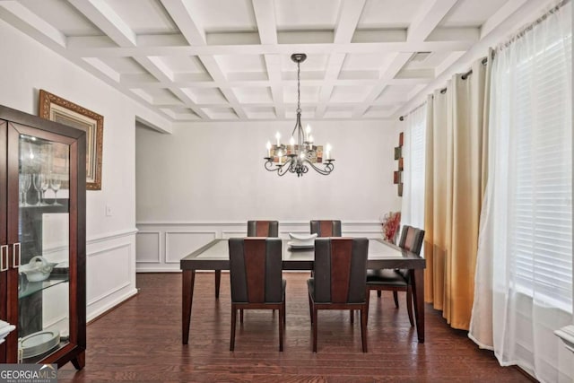 dining area with coffered ceiling, dark hardwood / wood-style flooring, a notable chandelier, and beam ceiling