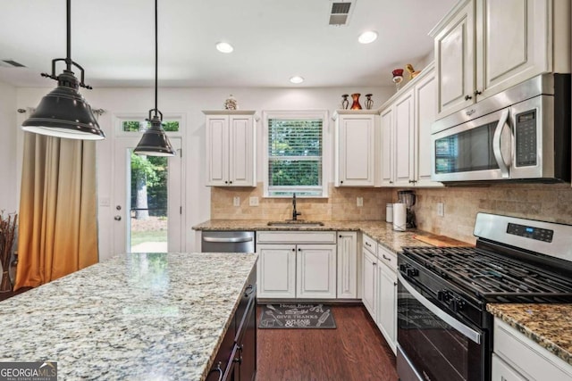 kitchen featuring appliances with stainless steel finishes, dark hardwood / wood-style flooring, sink, and white cabinets