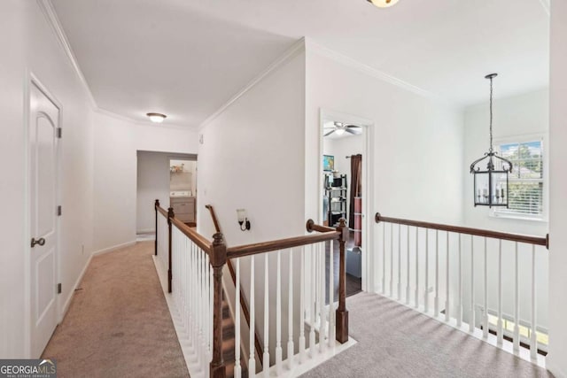 hall featuring ornamental molding, light colored carpet, and an inviting chandelier