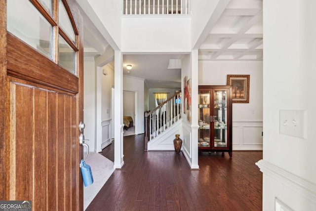 foyer entrance with coffered ceiling, beam ceiling, and dark hardwood / wood-style flooring