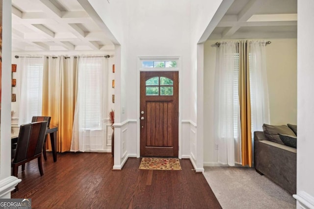 foyer entrance with plenty of natural light, coffered ceiling, dark hardwood / wood-style floors, and beamed ceiling