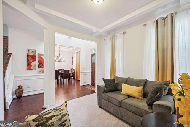 living room featuring ornamental molding, dark hardwood / wood-style flooring, and a notable chandelier