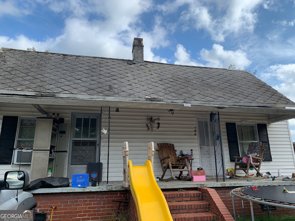 rear view of house featuring a porch