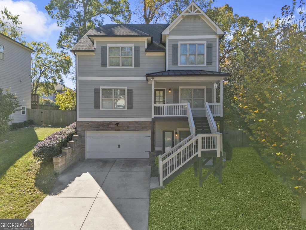 view of front facade featuring covered porch, a garage, and a front yard