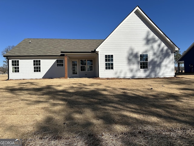 rear view of property with a yard