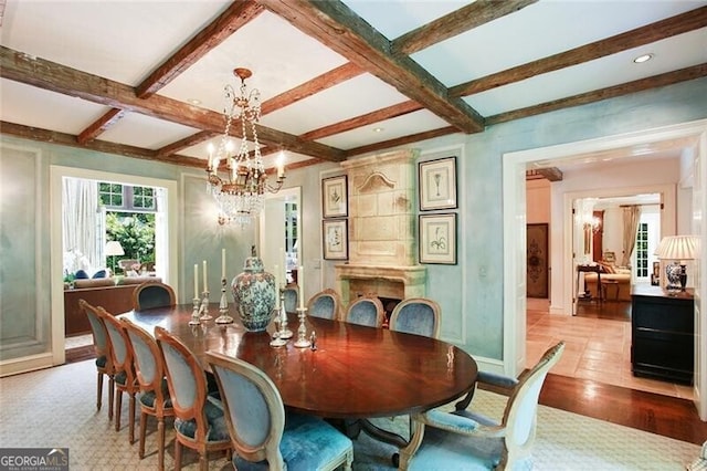 dining space featuring light hardwood / wood-style flooring, coffered ceiling, a notable chandelier, and beam ceiling