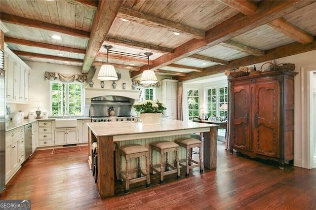 kitchen featuring dark wood-type flooring, a center island, white cabinets, and a breakfast bar