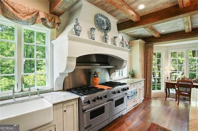 kitchen with wooden ceiling, light stone counters, dark hardwood / wood-style flooring, sink, and range with two ovens