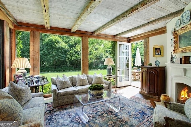 sunroom / solarium featuring a wealth of natural light, beamed ceiling, french doors, and wood ceiling