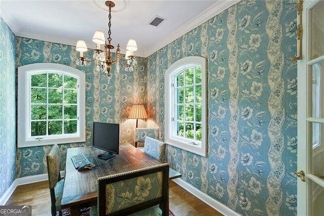 interior space with crown molding, a healthy amount of sunlight, hardwood / wood-style floors, and a chandelier