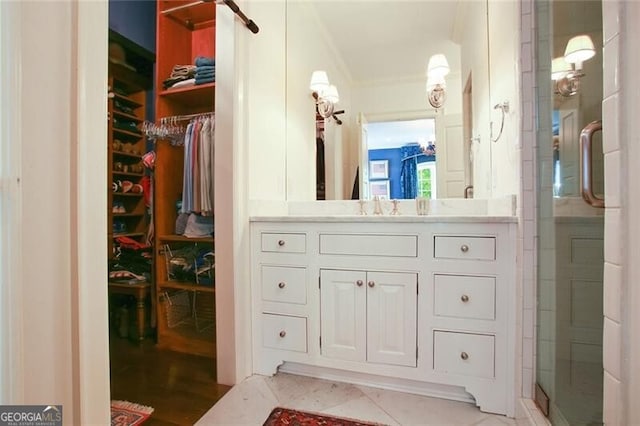 bathroom with crown molding, vanity, tile patterned floors, and walk in shower