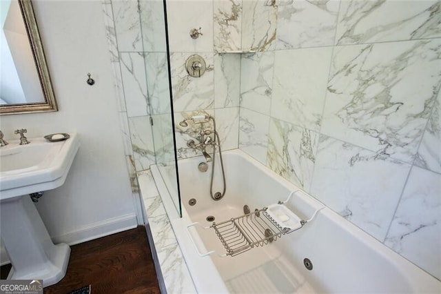 bathroom with hardwood / wood-style floors and tiled shower / bath