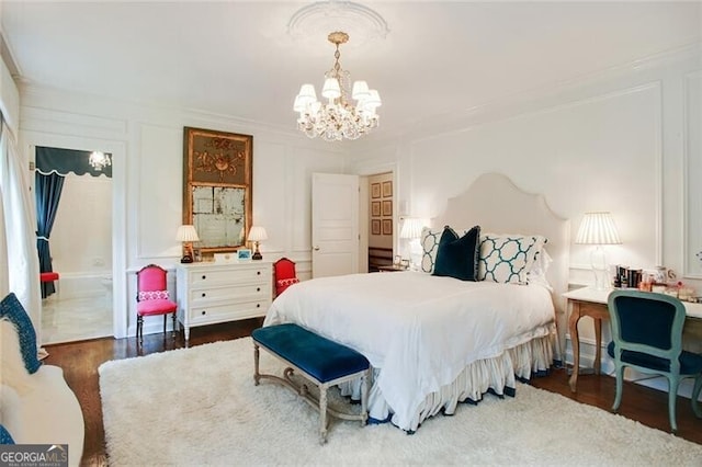 bedroom with ornamental molding, a chandelier, hardwood / wood-style floors, and ensuite bathroom