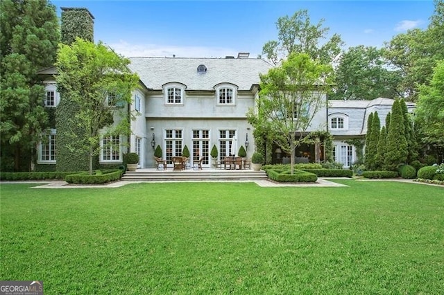 rear view of property with a lawn and french doors