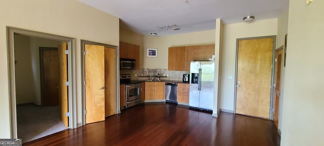 kitchen with appliances with stainless steel finishes, dark hardwood / wood-style flooring, and decorative backsplash