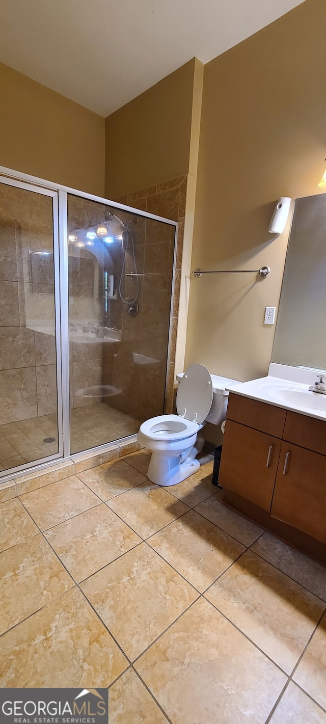 bathroom with vanity, toilet, and a shower with shower door