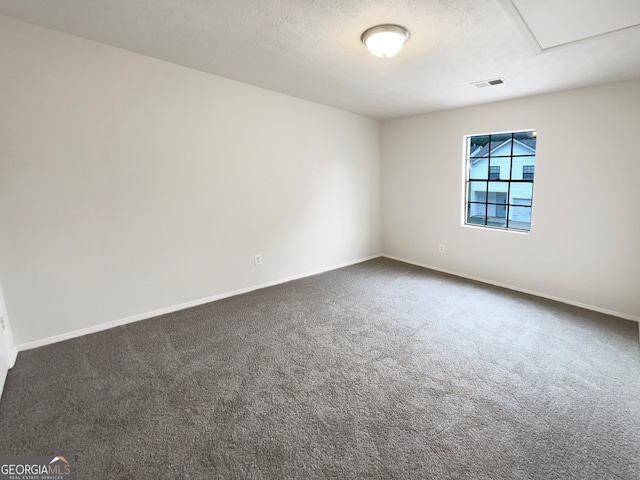 carpeted empty room with a textured ceiling