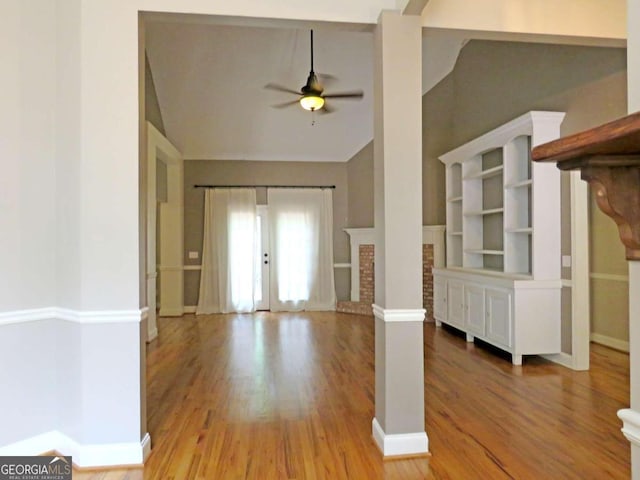 unfurnished living room featuring ceiling fan, vaulted ceiling, and light wood-type flooring