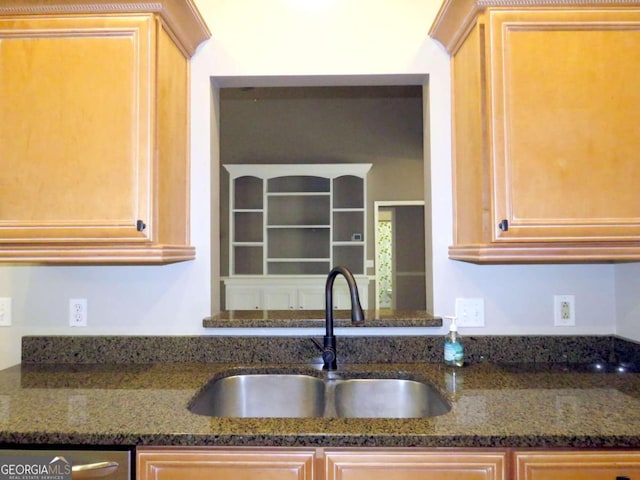 kitchen with light brown cabinetry, sink, stainless steel dishwasher, and dark stone counters