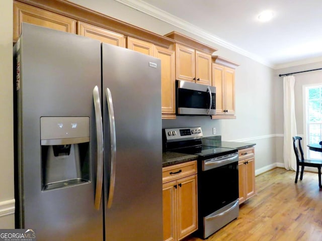 kitchen featuring light brown cabinets, stainless steel appliances, dark stone counters, light wood-type flooring, and crown molding