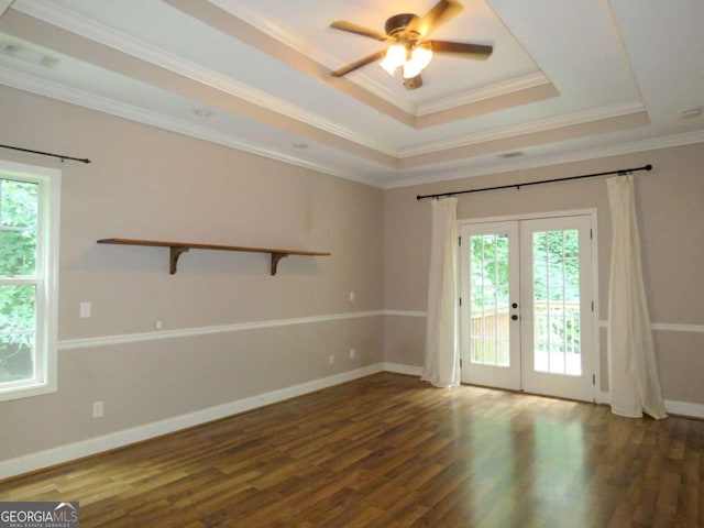 unfurnished room with ceiling fan, a raised ceiling, dark wood-type flooring, ornamental molding, and french doors