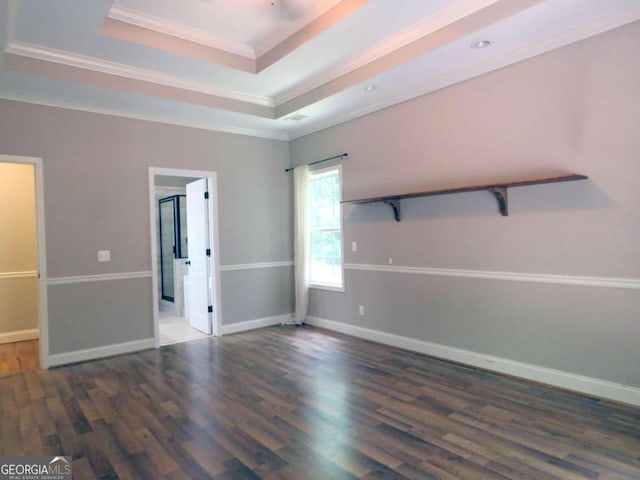 unfurnished room featuring dark hardwood / wood-style flooring, a raised ceiling, and crown molding