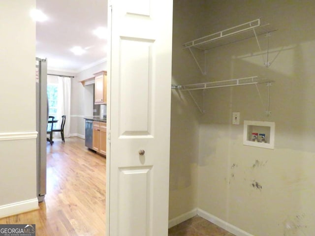 washroom featuring washer hookup, light hardwood / wood-style flooring, and crown molding