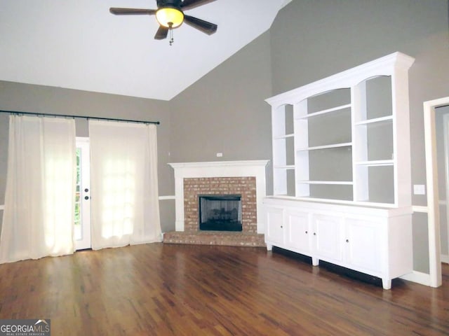 unfurnished living room featuring ceiling fan, dark hardwood / wood-style flooring, lofted ceiling, and a fireplace