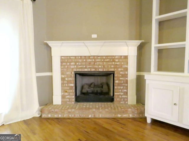 room details with a brick fireplace and hardwood / wood-style floors