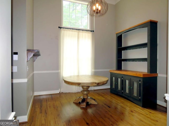 unfurnished dining area with wood-type flooring and an inviting chandelier