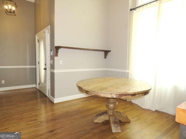 unfurnished dining area with dark wood-type flooring and a chandelier