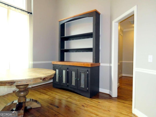 unfurnished dining area with ornamental molding and hardwood / wood-style floors